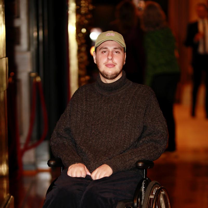 Porträt von Edoardo: großer, weißer Mann mit Käppi und Rollstuhl