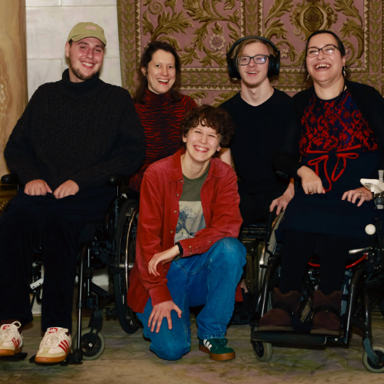 Gruppenfoto des open up Teams: 5 Personen, zwei benutzen einen Rollstuhl